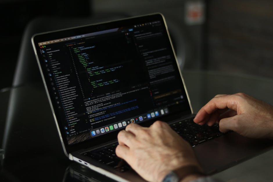 A person working on a laptop with a gardening-themed website open, showing an interface with code and images of garden layouts. The laptop is placed on a dark surface, and the person's hands are visib
